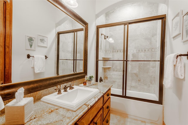 bathroom with vanity and shower / bath combination with glass door