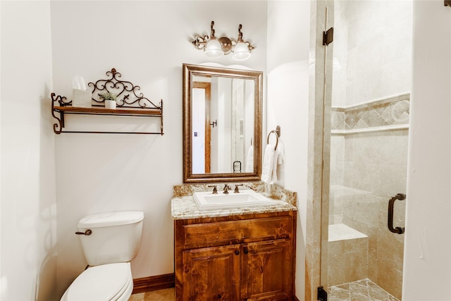 bathroom featuring vanity, a shower with shower door, and toilet