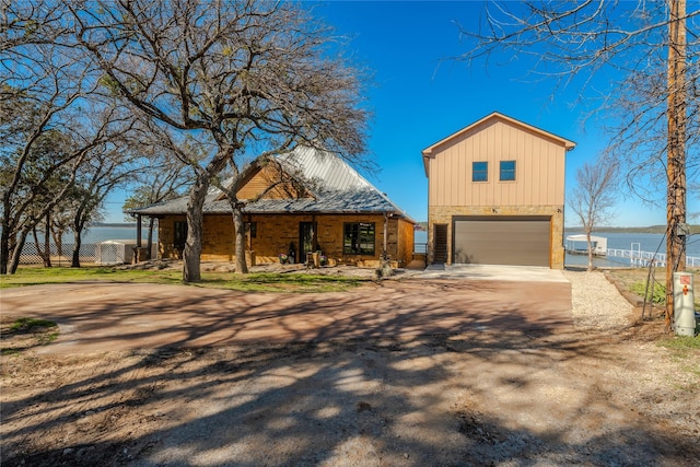 view of front facade with a water view, a porch, and a garage