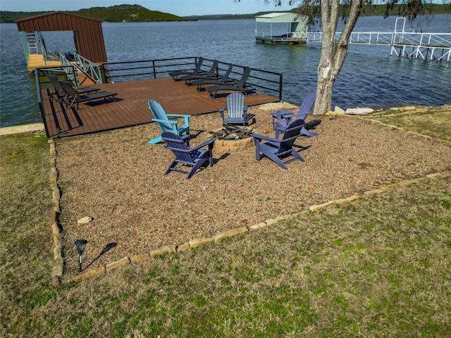 view of dock with an outdoor fire pit and a water view