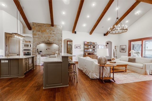 living room with an inviting chandelier, dark hardwood / wood-style floors, and high vaulted ceiling