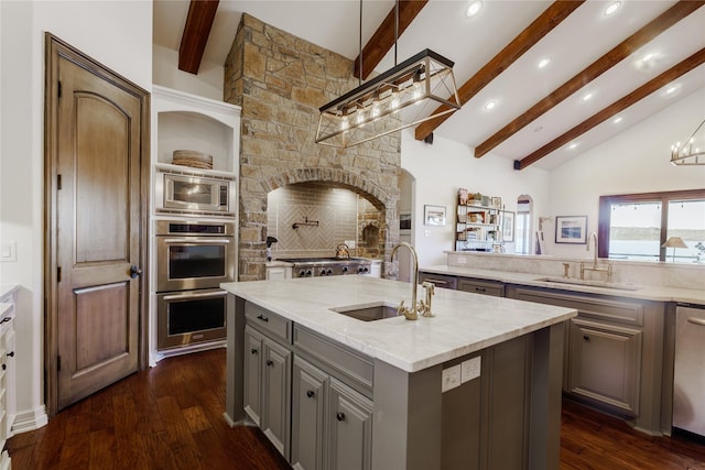 kitchen with sink, gray cabinets, an island with sink, and appliances with stainless steel finishes