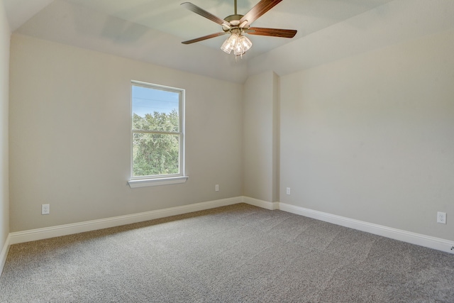 empty room featuring vaulted ceiling, light colored carpet, and ceiling fan