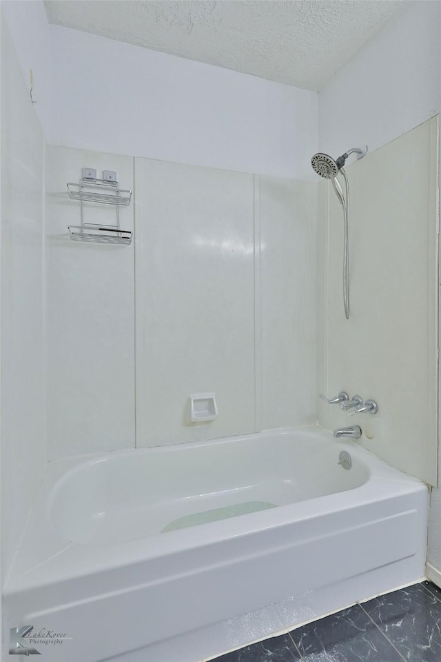 bathroom featuring shower / tub combination and a textured ceiling