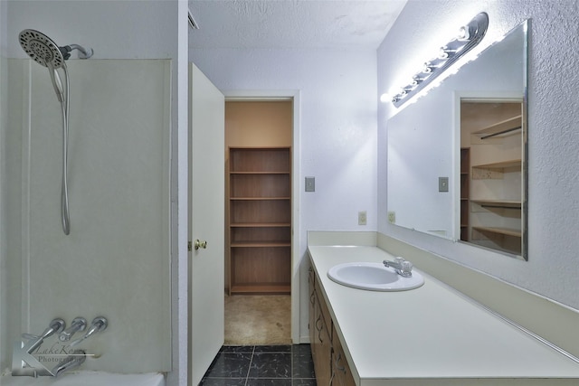 bathroom featuring shower / tub combination, vanity, and a textured ceiling