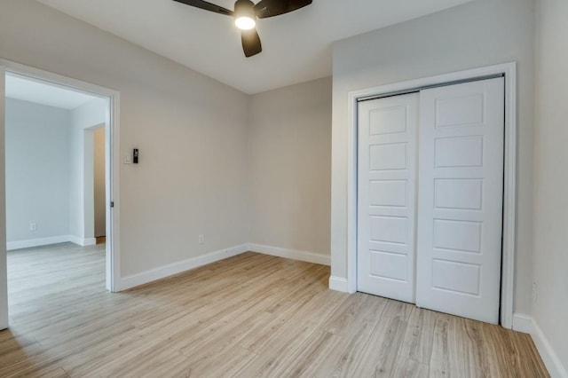 unfurnished bedroom with ceiling fan, light hardwood / wood-style floors, and a closet