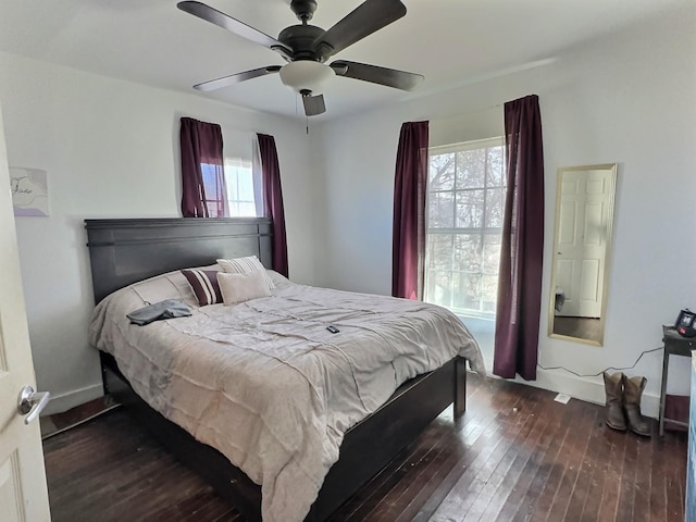 bedroom with multiple windows, dark wood-type flooring, and ceiling fan