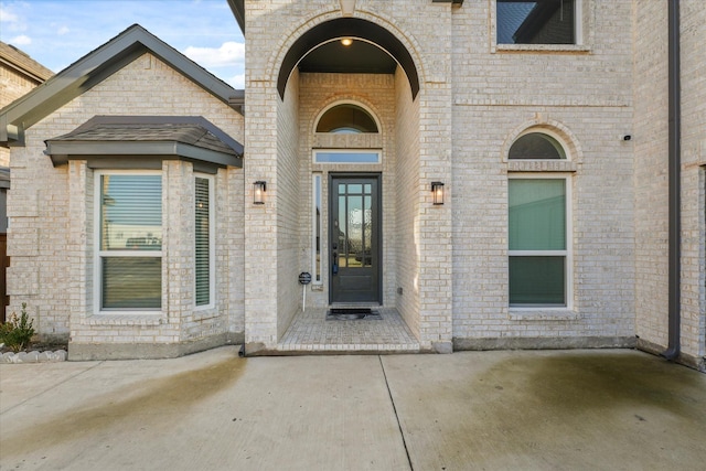 view of exterior entry featuring a patio