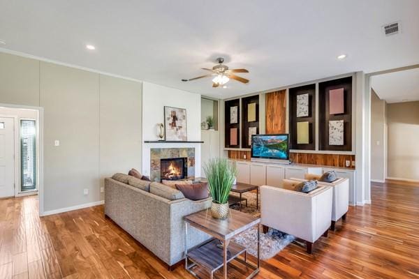 living room featuring hardwood / wood-style flooring, a fireplace, and ceiling fan