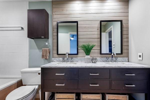 bathroom featuring vanity, a tub, and toilet