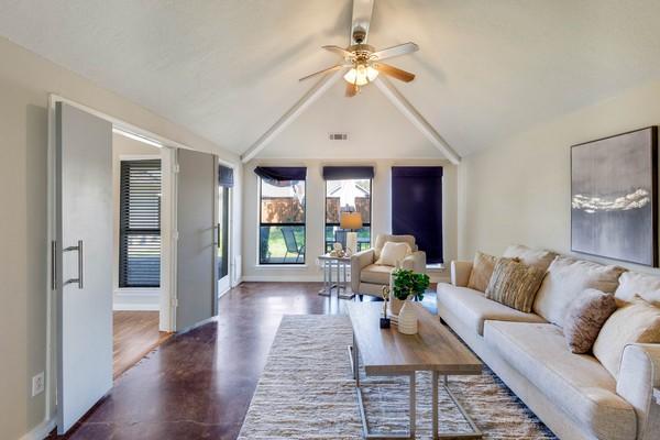 living room featuring ceiling fan and lofted ceiling