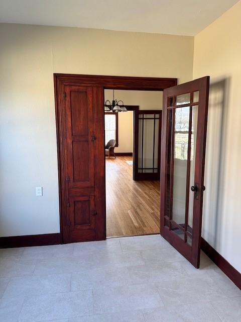 hall featuring an inviting chandelier and french doors