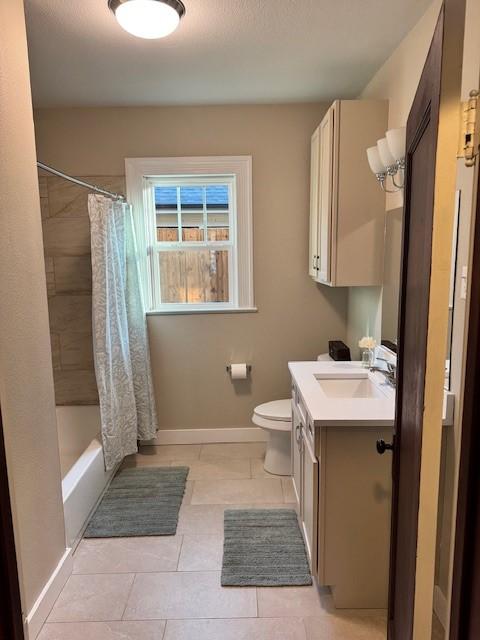 full bathroom featuring vanity, tile patterned floors, shower / bath combo with shower curtain, and toilet