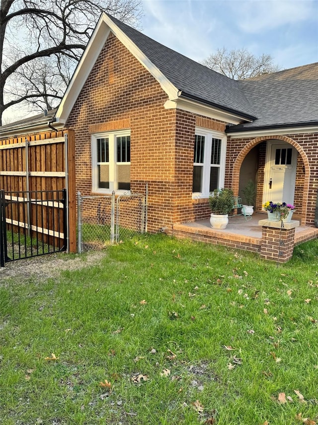 view of side of property featuring a patio area and a lawn