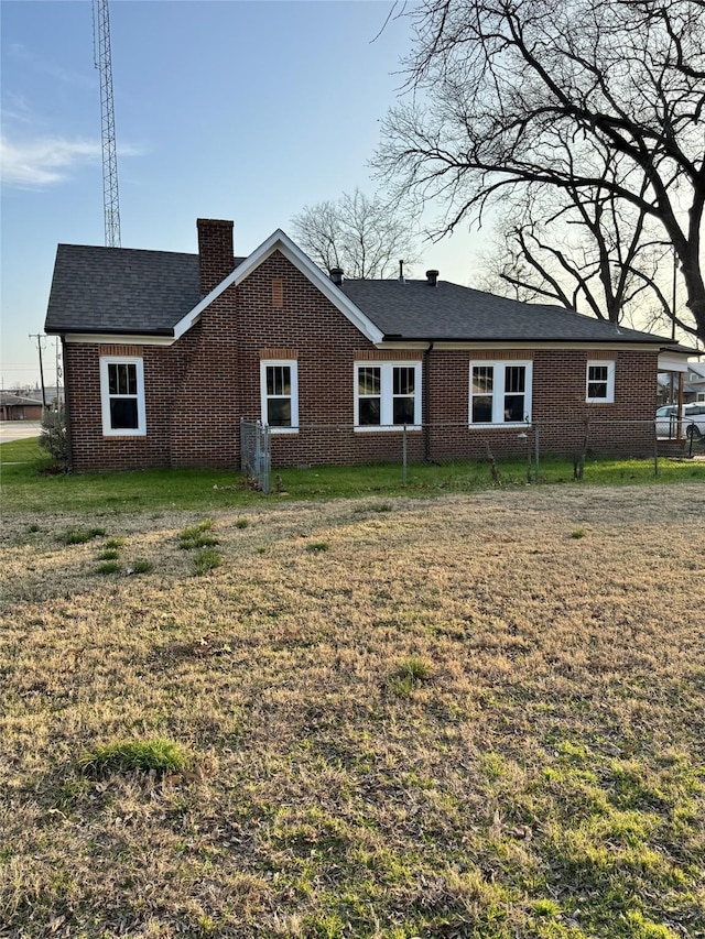 rear view of house featuring a yard