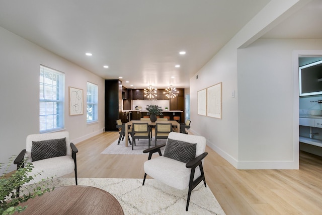 living room featuring a chandelier and light wood-type flooring