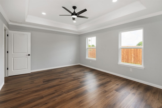 spare room featuring crown molding, dark hardwood / wood-style floors, a raised ceiling, and ceiling fan