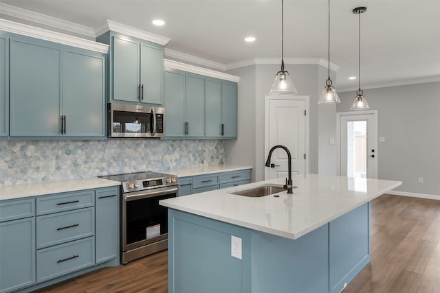 kitchen featuring sink, tasteful backsplash, appliances with stainless steel finishes, an island with sink, and pendant lighting