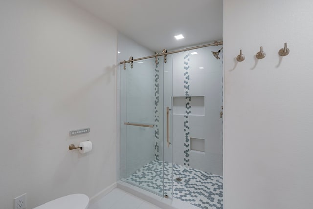 bathroom with toilet and an enclosed shower