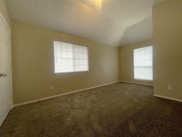 carpeted spare room with vaulted ceiling