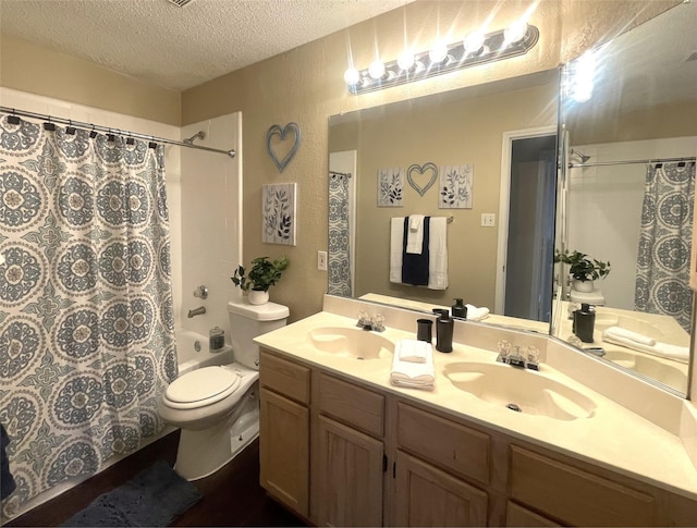 full bathroom with vanity, shower / bath combination with curtain, a textured ceiling, and toilet