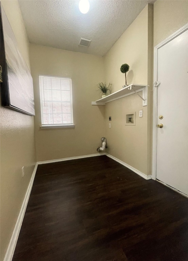 laundry room with washer hookup, electric dryer hookup, dark hardwood / wood-style floors, and a textured ceiling