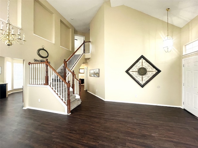 foyer with dark hardwood / wood-style flooring, a notable chandelier, and high vaulted ceiling