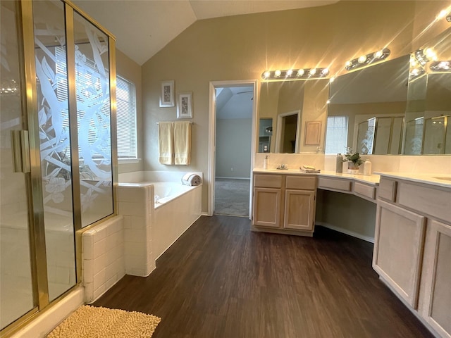 bathroom with vanity, hardwood / wood-style flooring, vaulted ceiling, and shower with separate bathtub