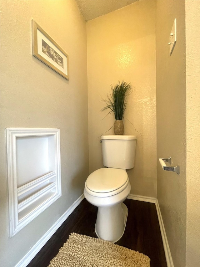 bathroom featuring hardwood / wood-style floors and toilet