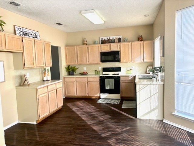 kitchen featuring stove, backsplash, dark hardwood / wood-style floors, and light brown cabinets