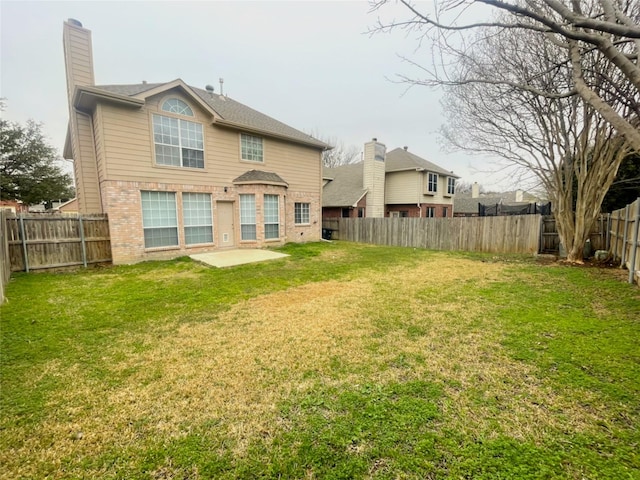 back of house with a yard and a patio