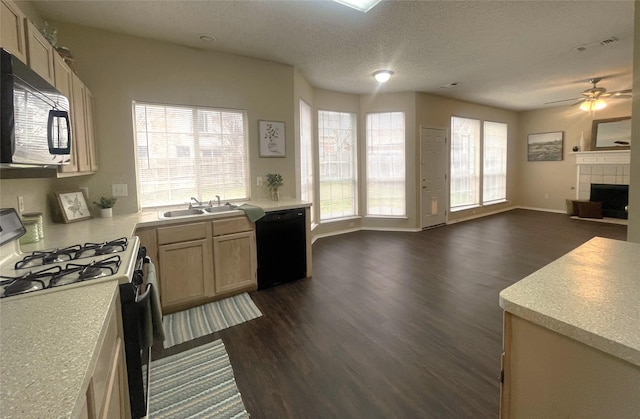 kitchen with dark hardwood / wood-style floors, a fireplace, light brown cabinetry, black appliances, and a textured ceiling