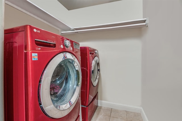 laundry area featuring washing machine and dryer and light tile patterned floors