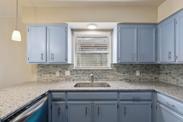 kitchen featuring blue cabinetry, stainless steel dishwasher, decorative light fixtures, and sink