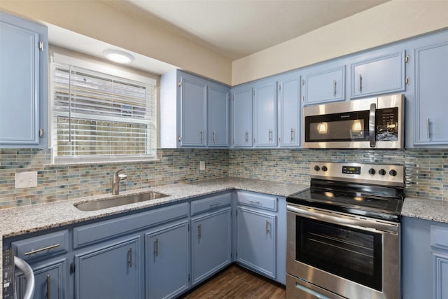 kitchen featuring sink, dark wood-type flooring, blue cabinetry, backsplash, and stainless steel appliances