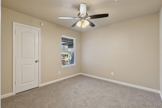 empty room featuring ceiling fan and carpet