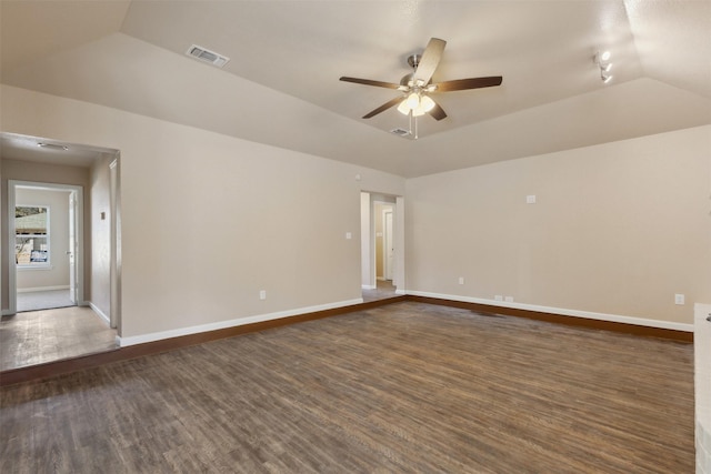 empty room featuring a raised ceiling, lofted ceiling, dark wood-type flooring, and ceiling fan