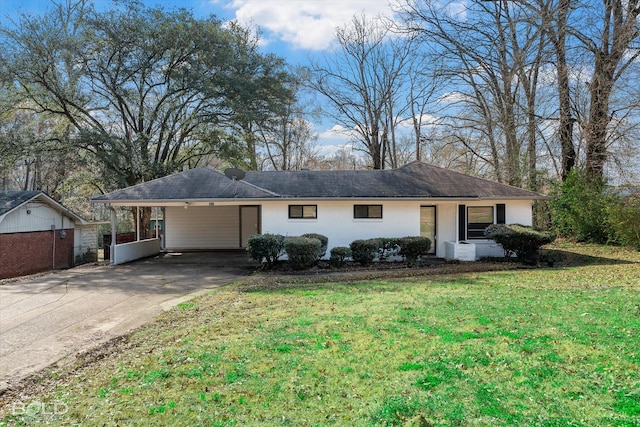 ranch-style house featuring an attached carport, concrete driveway, and a front lawn