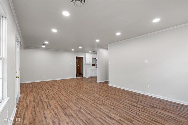 unfurnished living room with visible vents, crown molding, and recessed lighting