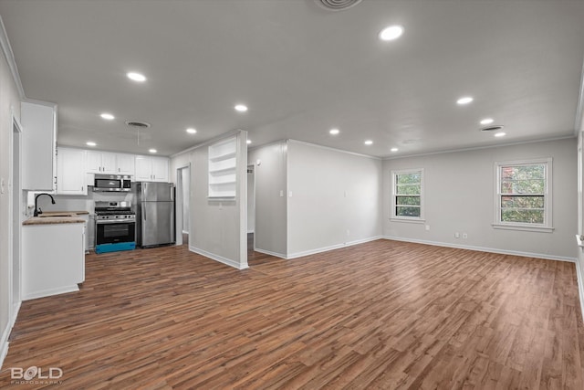 kitchen with white cabinetry, stainless steel appliances, dark wood-style flooring, and open floor plan