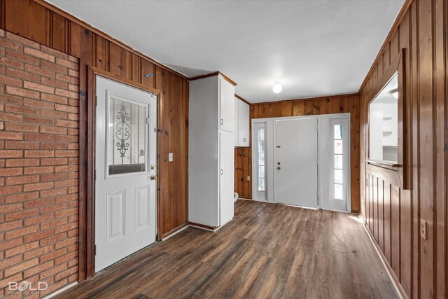 kitchen featuring appliances with stainless steel finishes, dark hardwood / wood-style floors, white cabinetry, sink, and dark stone countertops