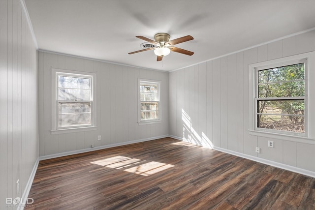 spare room with ceiling fan, baseboards, ornamental molding, and dark wood finished floors