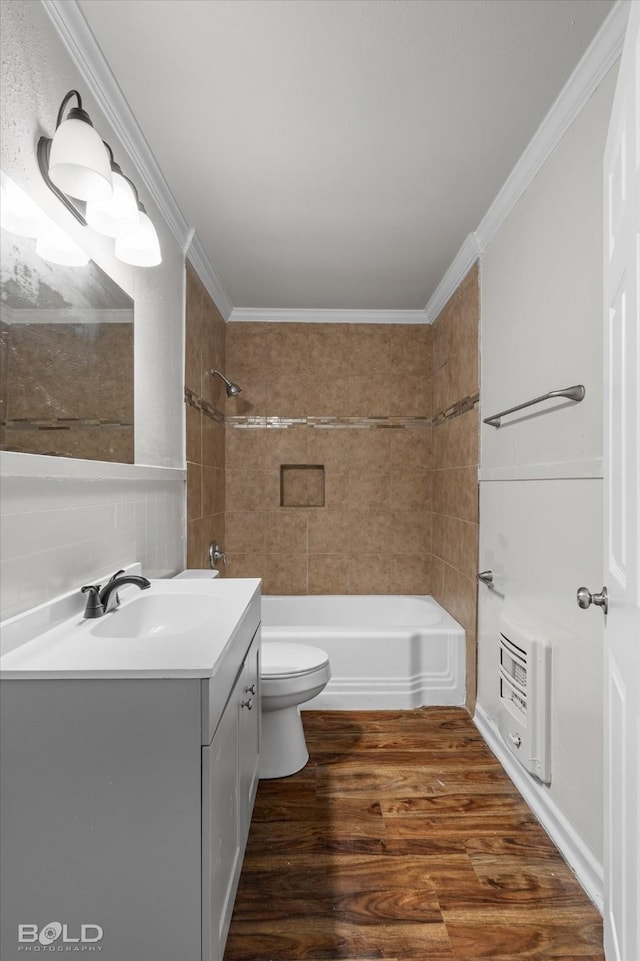 bathroom featuring shower / tub combination, wood finished floors, heating unit, crown molding, and vanity