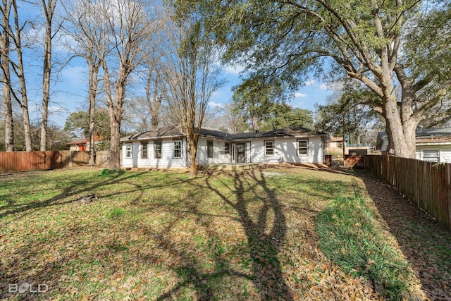 back of property with a lawn and a fenced backyard