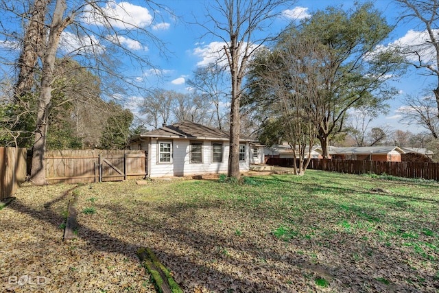 view of yard featuring a fenced backyard and a gate