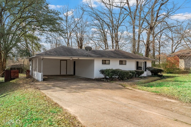 ranch-style home with driveway, a front yard, a carport, and brick siding