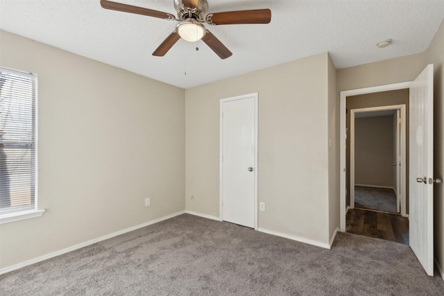 unfurnished bedroom featuring ceiling fan, carpet floors, and a textured ceiling