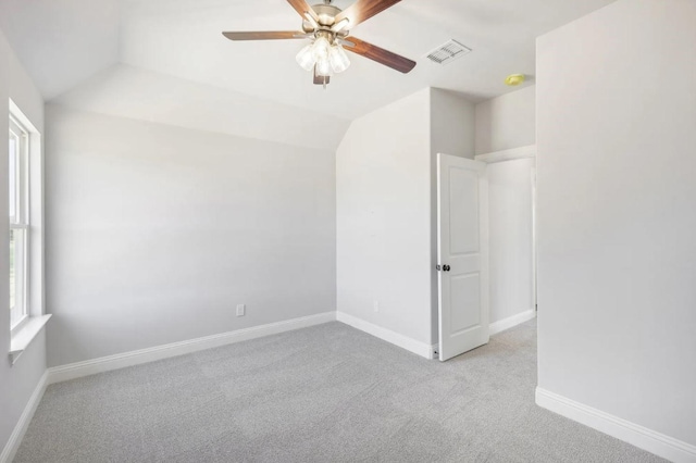 carpeted empty room featuring lofted ceiling, a wealth of natural light, and ceiling fan