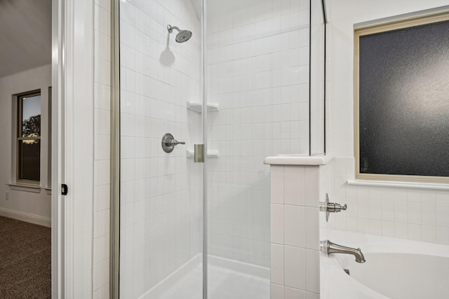 bathroom featuring shower with separate bathtub and tile walls