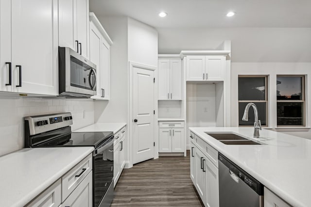 kitchen featuring dark wood-type flooring, sink, appliances with stainless steel finishes, decorative backsplash, and white cabinets